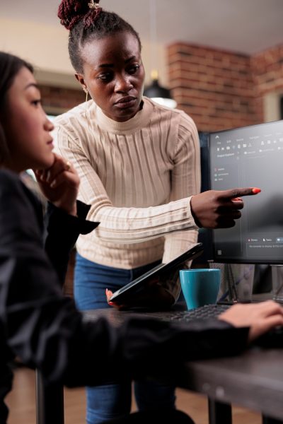 African american software developer pointing out cloud database processing algorithm error. Cybernetics engineers deciphering stolen corrupted and ecrypted important company files.